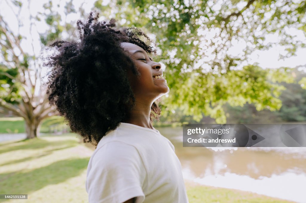 A child breathing clean air in nature smiling
