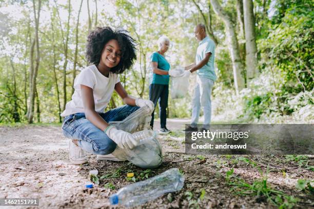 girl collecting garbage from nature - limpeza ambiental imagens e fotografias de stock