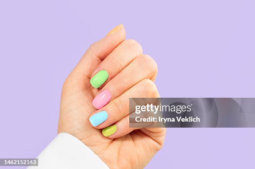 Elegant woman's hand with pastel color manicure on Easter Holiday. Trendy Color of the Year 2022 Very Peri purple violet lavender color background. Woman dressed in fashionable white shirt. Elegant woman's hand with pastel color manicure on Easter Holiday. Trendy Color of the Year 2022 Very Peri purple violet lavender color background. Woman dressed in fashionable white shirt.