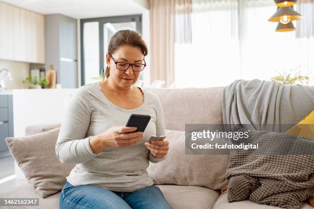 woman using phone searching medicine information - blister pack stock pictures, royalty-free photos & images