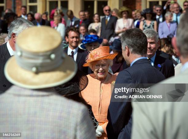 Britain's Queen Elizabeth II greets guests during a garden party in honour of her diamond jubilee at the Queen's Sandringham Estate in Norfolk on...