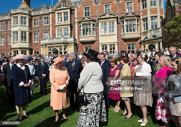 Queen Elizabeth II talks with guests during a garden party in honour of her Diamond Jubilee at the Queen's Sandringham Estate on June 12, 2012 in...