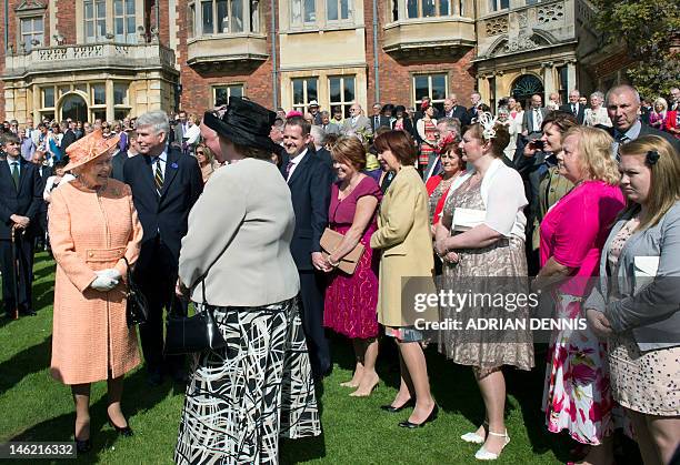 Britain's Queen Elizabeth II greets guests during a garden party in honour of her diamond jubilee at the Queen's Sandringham Estate in Norfolk on...