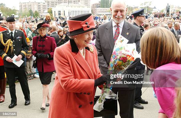 Queen Elizabeth receives flowers from a Canadian crowd before a luncheon October 6, 2002 in British Columbia, Canada. The visit is part of a...