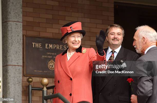 Queen Elizabeth waves to the crowd before entering the hotel for a luncheon October 6, 2002 in British Columbia, Canada. The Queen is with Ian...