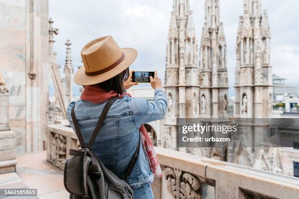 turista feminina jovem que tira uma foto da vista da catedral em milão - milan cathedral - fotografias e filmes do acervo