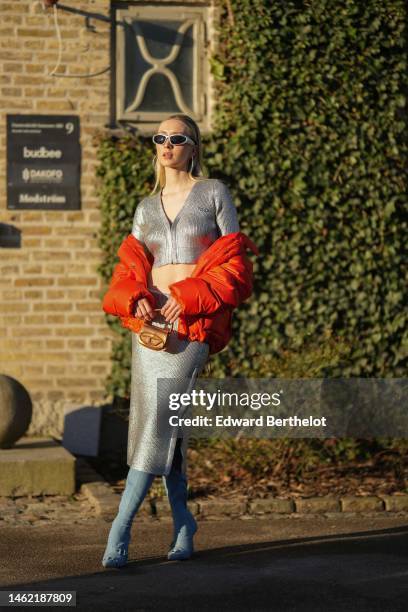 Guest wears silver sunglasses, silver earrings, a silver metallic in coated canvas buttoned / long sleeves / cropped top, a matching high waist...