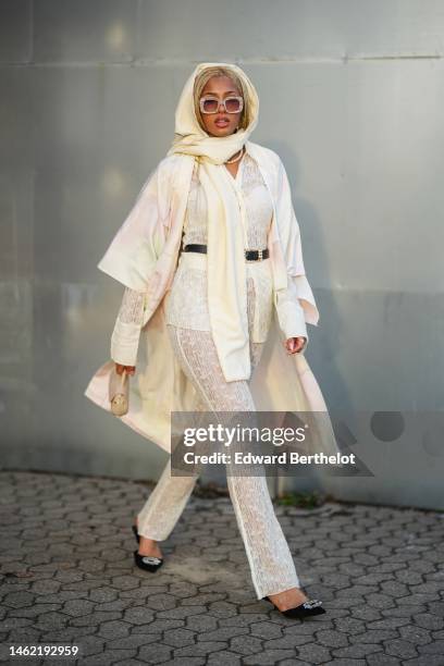 Guest wears a white scarf, beige and white marble print pattern sunglasses, a white pearls necklace, a white lace print pattern silk shirt, a white...