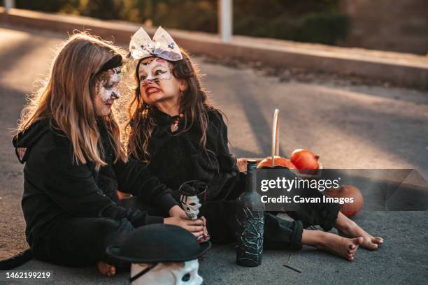 two little girls dressed as black cats celebrating a halloween party - halloween cats stock-fotos und bilder