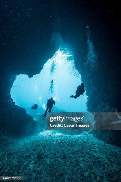 diver's exploring underwater cave in the south andaman sea - höhlenforscher stock-fotos und bilder