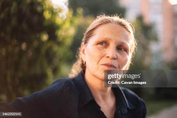 portrait of thoughtful mature business woman looking away in park - ukraine people stock pictures, royalty-free photos & images