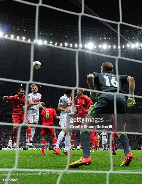 Sergey Ignashevich of Russia and Damien Perquis of Poland go up for a header during the UEFA EURO 2012 group A match between Poland and Russia at The...