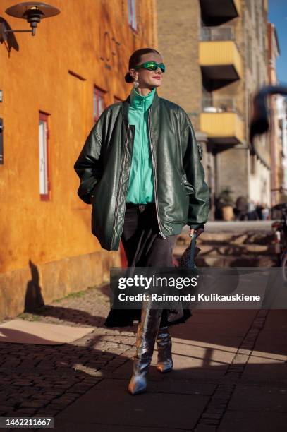 Marianne Theodorsen wearing a green leather jacket, black denim skirt, green sunglasses, silver shiny boots, and Fendi bag outside Mark Kenly Domino...