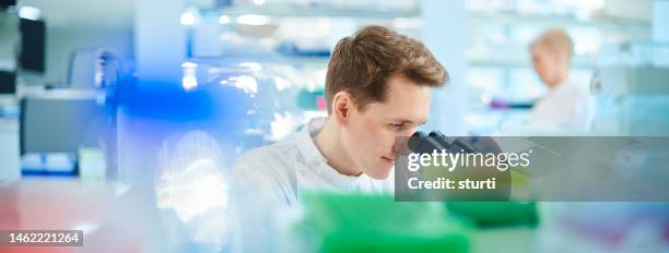 male biochemist in the lab - young man scientist stock pictures, royalty-free photos & images