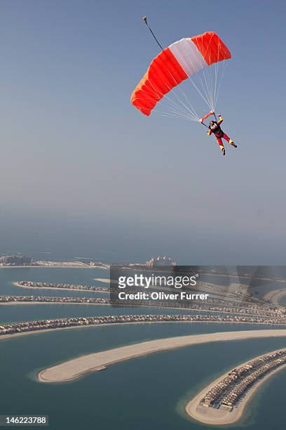 skydiver under canopy over the dubai palm islands - skydiving stock pictures, royalty-free photos & images