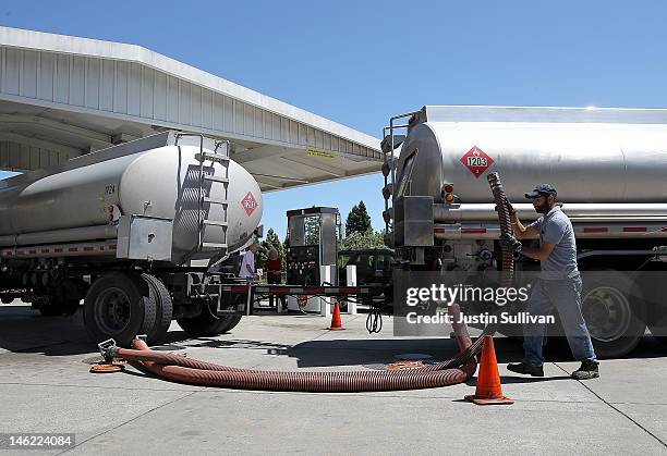 Gasoline truck driver Bhupinder Singh moves a fuel hose as he makes a gasoline delivery to a gas station on June 12, 2012 in San Anselmo, California....