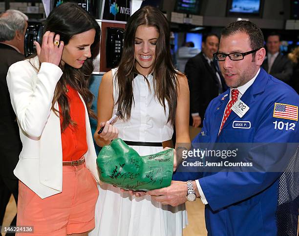 Actors Jordana Brewster and Julie Gonzalo of the cast of the new series "Dallas" on the exchange floor with a trader during a visit to The New York...