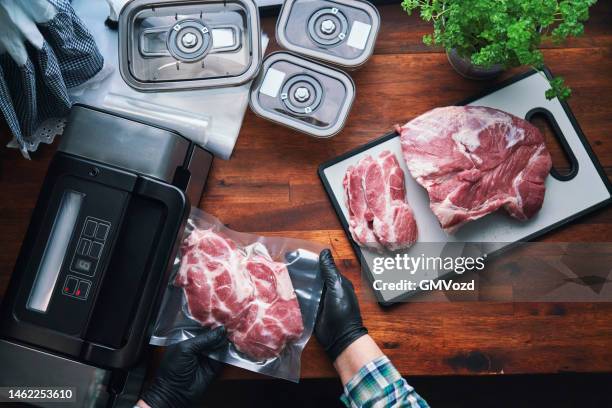 food safety - preserving fresh pork chops in a plastic bag with a vacuume sealer - vacuum stockfoto's en -beelden