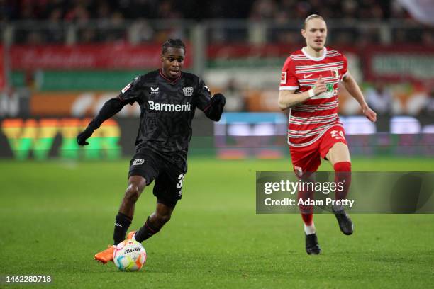 Jeremie Frimpong of Bayer 04 Leverkusen runs with the ball whilst under pressure from Fredrik Jensen of FC Augsburg during the Bundesliga match...