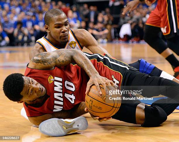 Udonis Haslem of the Miami Heat holds the ball on the floor in front of Kevin Durant of the Oklahoma City Thunder in the first quarter in Game One of...