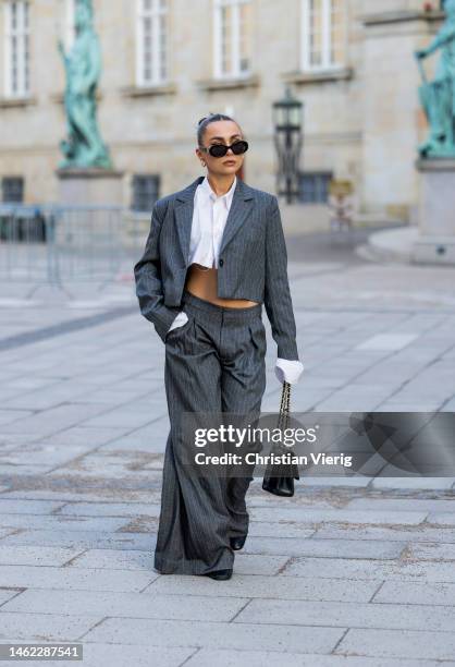 Anna Idriess wears grey cropped blazer, wide let pants, cropped white blouse black Chanel bag outside Gestuz during the Copenhagen Fashion Week...