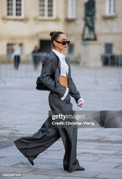 Anna Idriess wears grey cropped blazer, wide let pants, cropped white blouse black Chanel bag outside Gestuz during the Copenhagen Fashion Week...