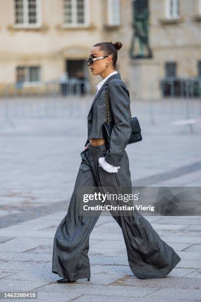 Anna Idriess wears grey cropped blazer, wide let pants, cropped white blouse black Chanel bag outside Gestuz during the Copenhagen Fashion Week...