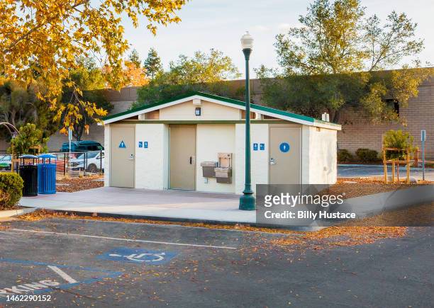 outdoor public restrooms with recycling containers in a city park. - handicap parking space stock pictures, royalty-free photos & images