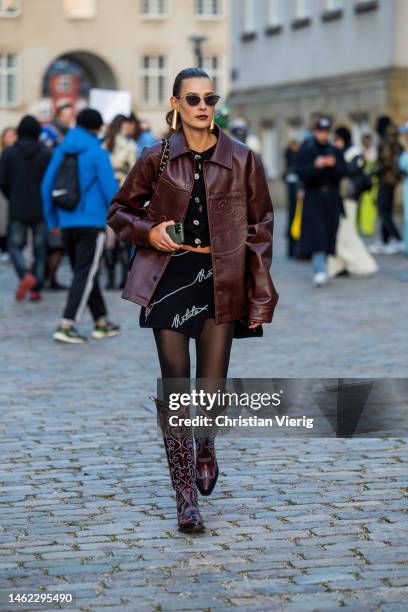 Vera van Erp wears burgundy bag, skirt with print, button up top, tights, cowboy boots outside Gestuz during the Copenhagen Fashion Week...