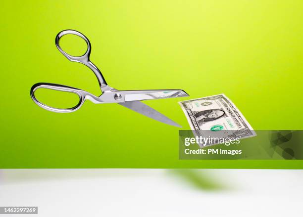 cutting the budget - scissors and dollar - sparpaket stock-fotos und bilder