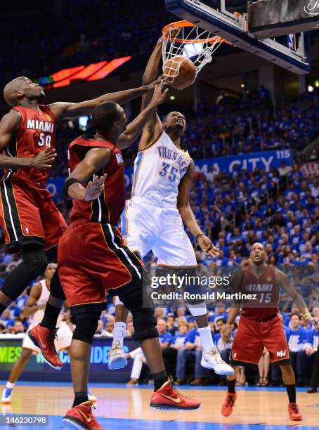 Kevin Durant of the Oklahoma City Thunder dunks the ball over Joel Anthony and Chris Bosh of the Miami Heat in the second quarter in Game One of the...