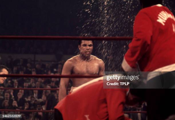 American heavyweight boxing champion Muhammad Ali is sprayed with water as trainer Angelo Dundee and assistant trainer Drew Bundini Brown climb into...