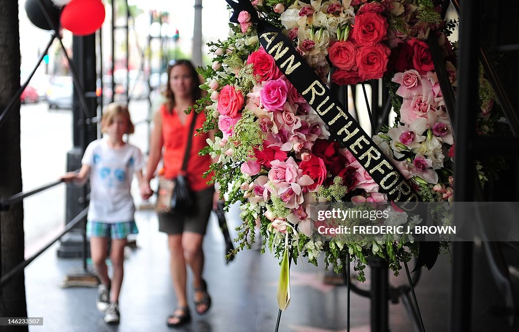 A mother and child approach a wreath of 