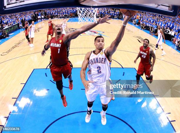 Thabo Sefolosha of the Oklahoma City Thunder lays the ball up in front of Chris Bosh of the Miami Heat in the second half in Game One of the 2012 NBA...