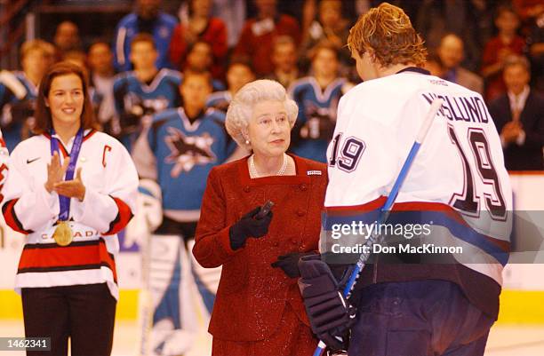 Canadian Womens Olympic winter games gold medal hockey team captain Cassie Campbell watches as Vancouver Canucks captain Markus Naslund hands Queen...