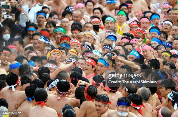 Half-naked men in traditional 'fundoshi' loincloths tussle with one another, trying to touch the man called a 'shin otoko' to ward off evil fortune,...