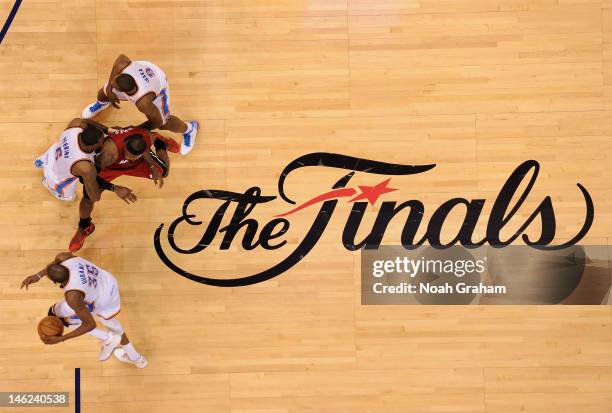 Kevin Durant of the Oklahoma City Thunder drives to the basket as teammates Kendrick Perkins and Serge Ibaka block LeBron James of the Miami Heat...