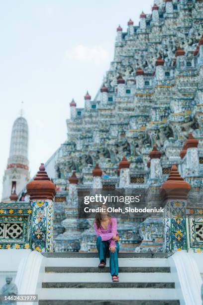woman sitting on the background of the pagoda in wat arun temple - theravada stock pictures, royalty-free photos & images