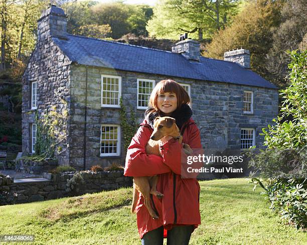 proud home owner with pet dog - cottage exterior stockfoto's en -beelden