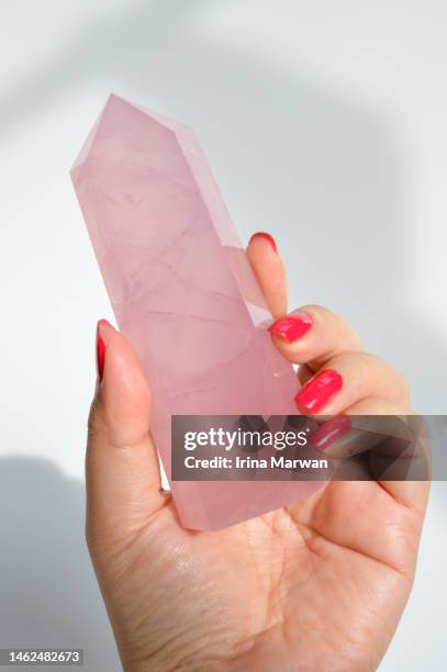 woman holding rose quartz crystal tower - opal gemstone stock pictures, royalty-free photos & images