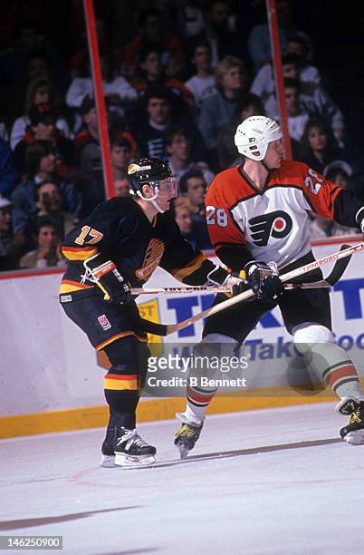 Vladimir Krutov of the Vancouver Canucks defends against Kjell Samuelsson of the Philadelphia Flyers circa 1990 at the Spectrum in Philadelphia,...