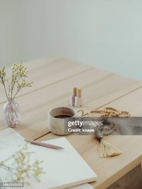 modern still life at home coffee cup note book zen buddha necklace and pen on table - bullet journal stock pictures, royalty-free photos & images