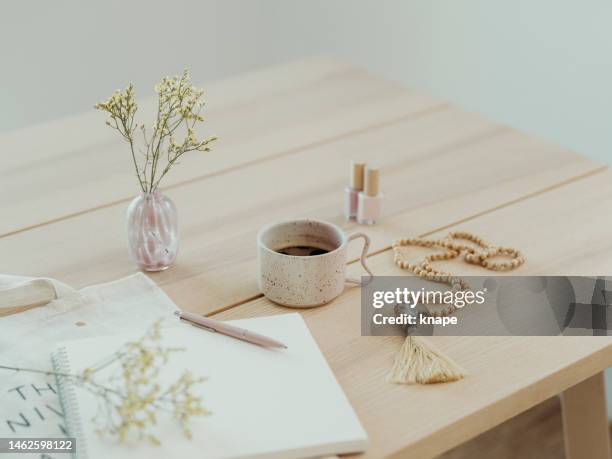 modern still life at home coffee cup note book zen buddha necklace and pen on table - bullet journal stock pictures, royalty-free photos & images