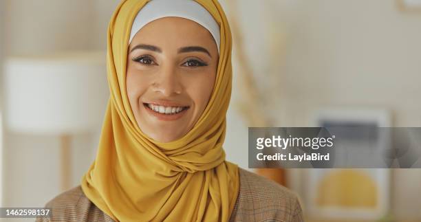 lächeln, porträt und muslimische frau, glücklich und zufrieden in ihrem zuhause, sorglos und chillend vor verschwommenem hintergrund. gesicht, islamisch und mädchen entspannen sich in einem wohnzimmer und genießen einen ruhigen freien tag drinnen - emirati face smile stock-fotos und bilder