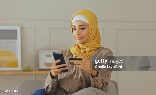 kreditkarte, muslim oder frau mit telefon auf online-shopping oder zahlung, internet-kauf oder e-commerce im wohnzimmer. fintech, zu hause oder islamisches mädchen hände auf smartphone für handel, banking oder investieren - arab culture stock-fotos und bilder