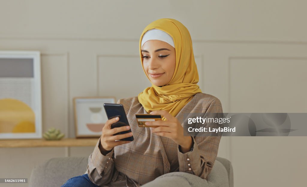 Credit card, muslim or woman with phone on online shopping or payment, internet purchase or ecommerce in living room. Fintech, home or Islamic girl hands on smartphone for trading, banking or invest