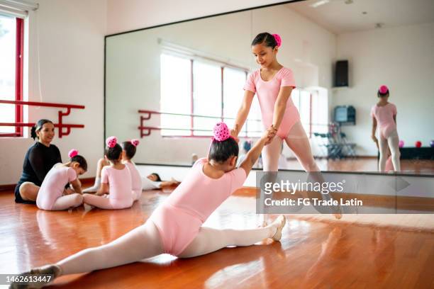 ballet dancers doing stretch exercises at the dance studio - leg stretch girl stock pictures, royalty-free photos & images