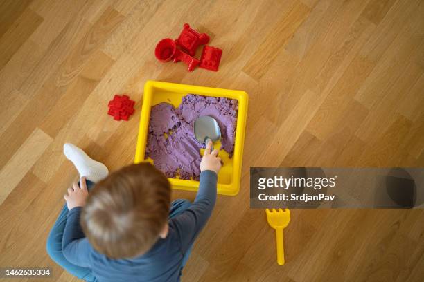 hochwinkelansicht eines kleinkindes, das mit hydrophober sand spielt - 1 kid 1 sandbox stock-fotos und bilder