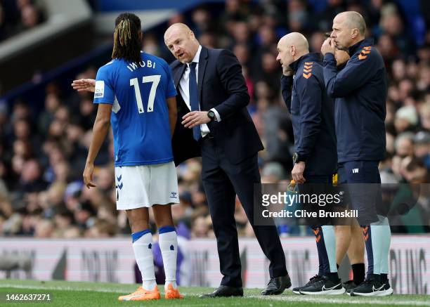 Sean Dyche, Manager of Everton, interacts with Alex Iwobi of Everton during the Premier League match between Everton FC and Arsenal FC at Goodison...