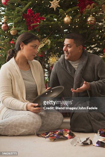 wife opening frying pan on christmas morning - disappointment gift stock pictures, royalty-free photos & images